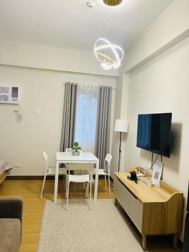 a living room with a white table and a tv at Casa Del Perucho in Trece Martires