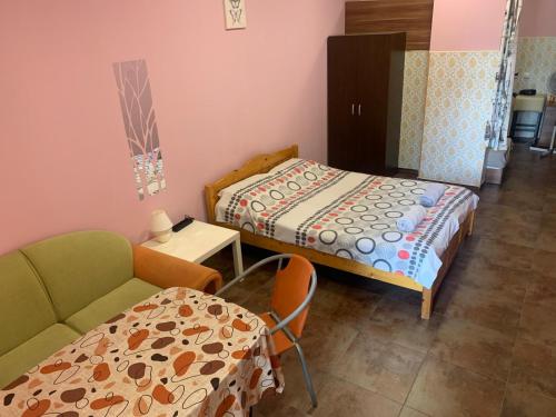 a bedroom with a bed and a table and a chair at Like Home Guest Rooms in Sofia
