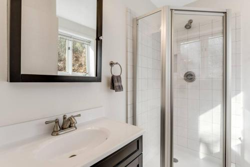 a white bathroom with a sink and a shower at Lakeside Serenity Mnt Views Decks Foosball in Lake Lure