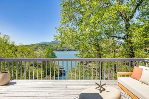 a balcony with a couch and a view of a lake at Lakeside Serenity Mnt Views Decks Foosball in Lake Lure