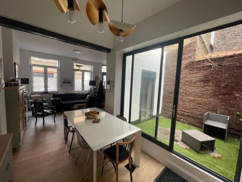 un salon avec une table et une grande fenêtre dans l'établissement Malouine de style idéale famille, à Dunkerque