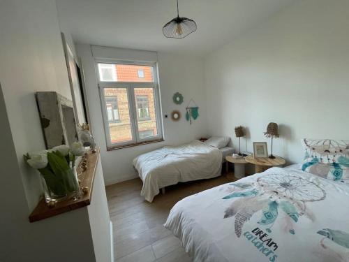 une chambre avec deux lits et une fenêtre dans l'établissement Malouine de style idéale famille, à Dunkerque