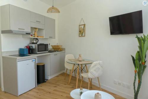 une cuisine avec une table, des chaises et une petite table dans l'établissement Palais Riviera chaleureux lumineux et climatisé, à Nice