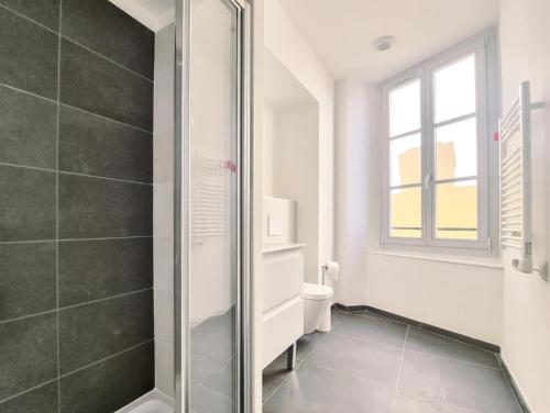 une salle de bain avec douche et toilettes et une fenêtre dans l'établissement Palais Riviera chaleureux lumineux et climatisé, à Nice