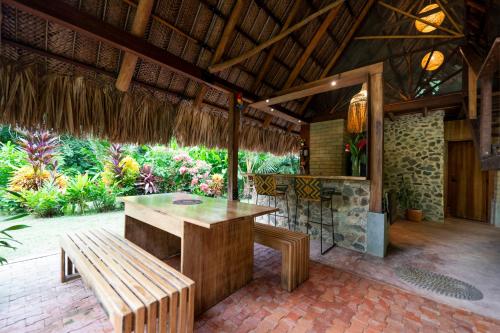 a patio with a wooden table and a bench at Canto Tayrona Ecolodges in Buritaca
