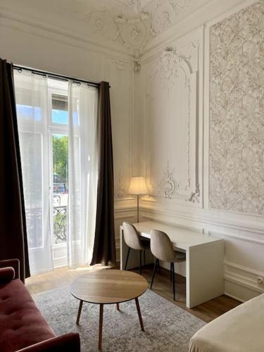 Cette chambre blanche dispose d'un bureau, de chaises et d'une fenêtre. dans l'établissement Casa Cēzane - Place de la Comédie, Montpellier, à Montpellier