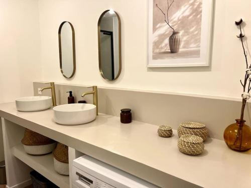 La salle de bains est pourvue de 2 lavabos et de miroirs sur un comptoir. dans l'établissement Casa Cēzane - Place de la Comédie, Montpellier, à Montpellier