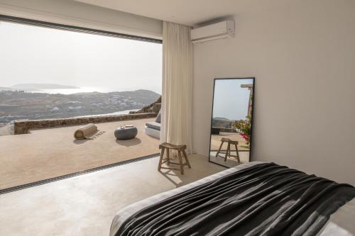 a bedroom with a large window with a view at Villa Maera Maximus in Mikonos