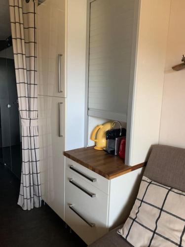 a small kitchen with a counter and a cabinet at Près des pistes - Plein sud - Vue incroyable in LʼHuez