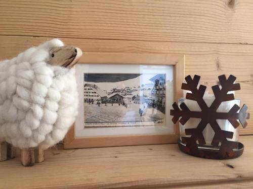 a stuffed animal is next to a picture and a photograph at Près des pistes - Plein sud - Vue incroyable in LʼHuez