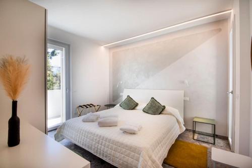 a white bedroom with a large white bed with pillows at Luxury House - Small Heated Pool in Bardolino