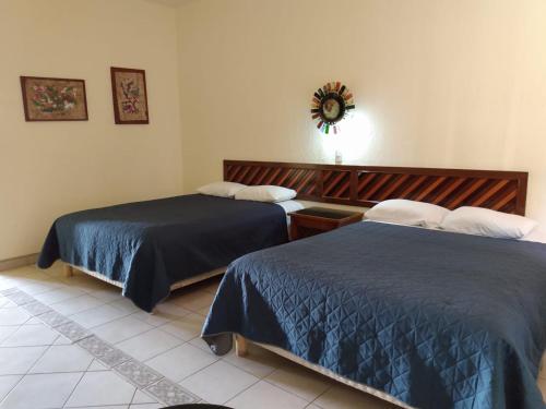 The Halfway Inn في Guerrero Negro: غرفة نوم بها سريران ومرآة على الحائط