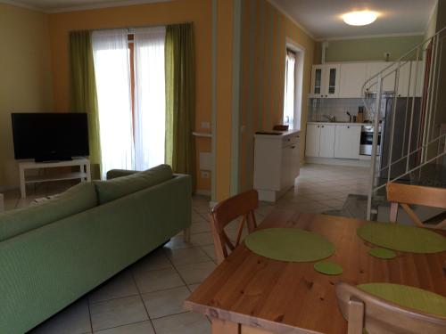 a living room with a green couch and a table at Appartamenti Girasole in Cannobio