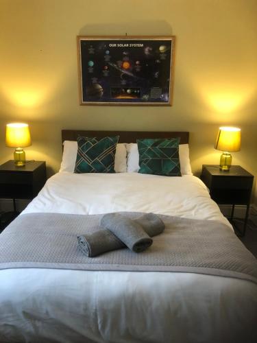 a bedroom with a large white bed with two lamps at City Centre One Bedroom Apartment Free Parking And internet in Hull