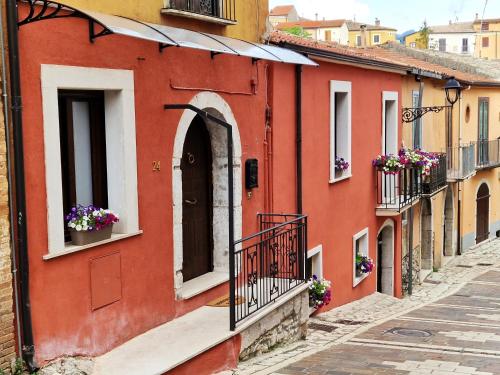 an alley in an old town with flowers in windows at la corte dei filangieri rooms in Candida