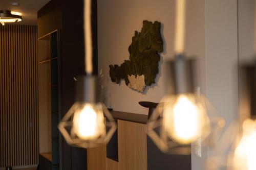 two lights on a wall in a room at Adlerblick Deluxe Annenheim in Annenheim