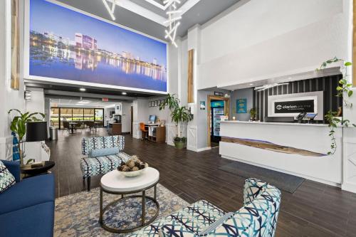a lobby with chairs and a table and a tv at Clarion Pointe Lakeland I-4 in Lakeland