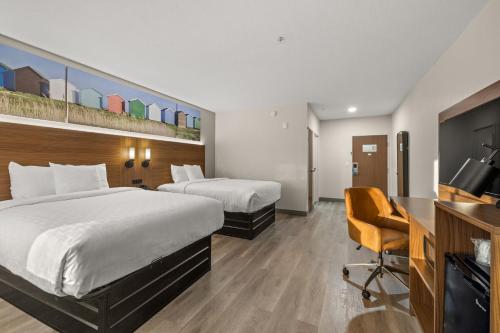 a hotel room with two beds and a desk at Clarion Pointe Lakeland I-4 in Lakeland