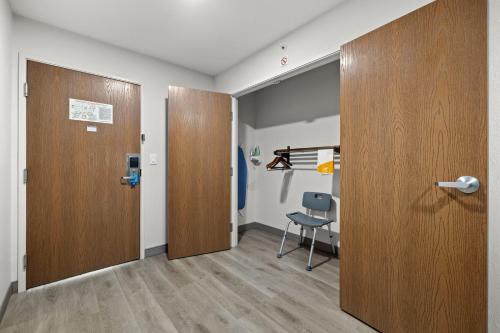 a room with two wooden doors and a chair at Clarion Pointe Lakeland I-4 in Lakeland