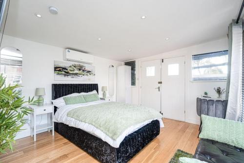 a white bedroom with a bed and a couch at Waterbank Cabin in Lower Sydenham Station