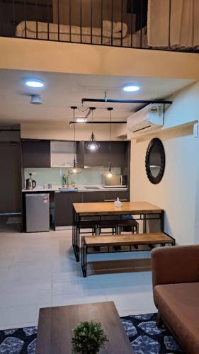 a living room with a table and a kitchen at Duplex Tamarind Suite Cyberjaya By NSB in Cyberjaya