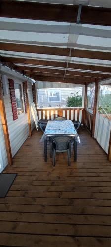 une terrasse en bois avec une table. dans l'établissement landes 460, à Gastes
