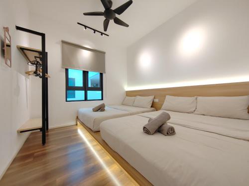 two beds in a room with a ceiling fan at Ipoh Sunway Onsen Suites and Tambun Guesthouse , 3-14pax 2parking by IWH in Ipoh