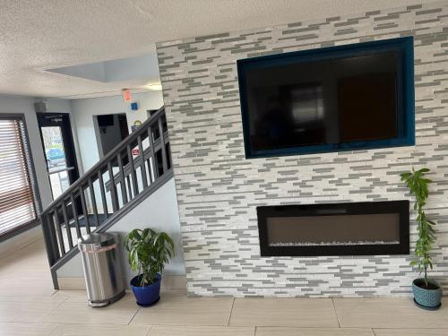 a fireplace with a flat screen tv on a brick wall at Days Inn by Wyndham Muncie -Ball State University in Muncie