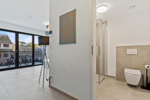 a bathroom with a toilet and a painting on the wall at Comfort & Style in Vibrant Luxembourg Coliving in Luxembourg