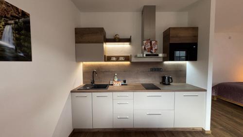 a kitchen with white cabinets and a sink at Vila Olívia - Apartmán Olívia 2 in Ružomberok