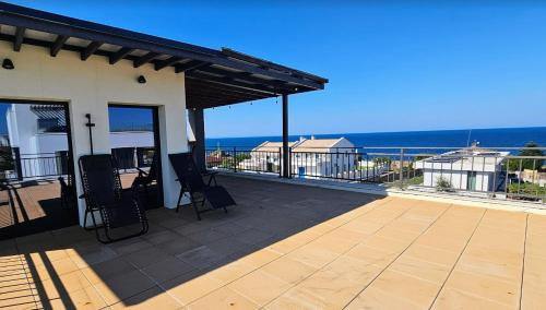 a patio with two chairs and the ocean in the background at 3-Bedroom Villa in Lozenets, Burgas, Bulgaria in Lozenets