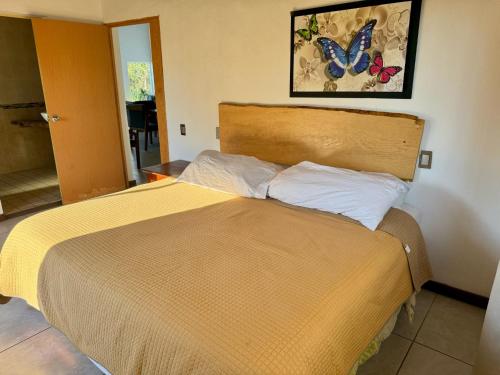 a bedroom with a bed with a butterfly on the wall at Herradura VIP Inn in Mazamitla
