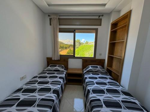 a room with three beds and a window at Good life Mimosa in Rcham