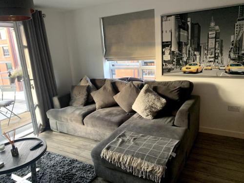 a living room with a couch and a table at Lovely 1 bedroom top floor flat at Chocolate Quarter near city of Bath in Keynsham
