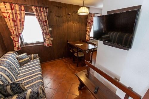 a living room with a couch and a television at Champoluc Apartment in Champoluc