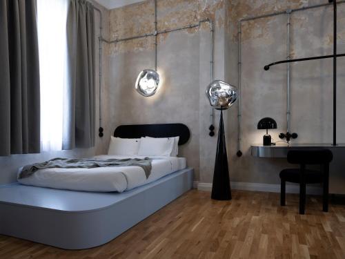 a bedroom with a bed and a desk and two lights at Hipsters Hotel in Thessaloniki