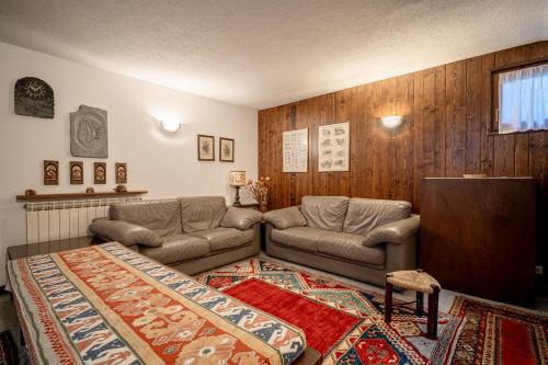 a living room with a couch and a tv at Champoluc Apartment in Champoluc