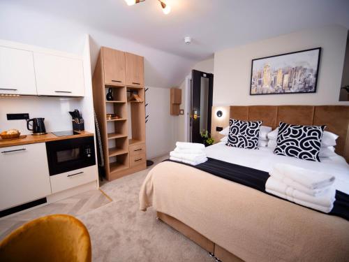 a bedroom with a large bed and a kitchen at Apart Hotel Rugby -Self Check In- in Rugby