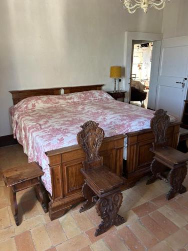 a bedroom with a large wooden bed with two chairs at Agriturismo Bibiano38 in Treia