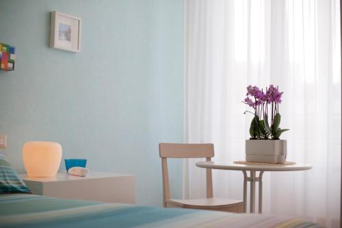 a bedroom with a table and a chair and a potted plant at Garibaldi R&B in Messina