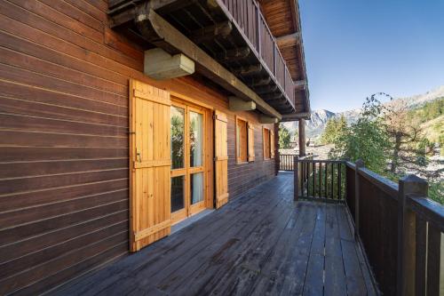 a wooden porch of a house with a door at Champoluc Apartment in Champoluc