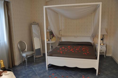 a bedroom with a canopy bed with red flowers on it at Marina Holiday & Spa in Balestrate