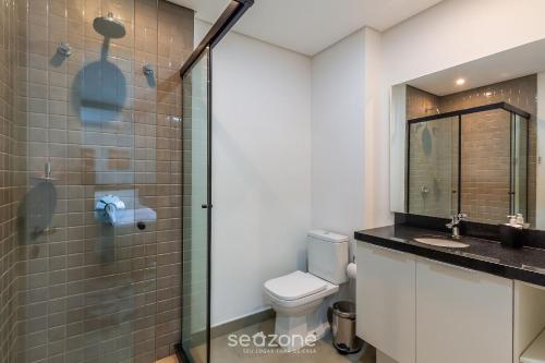 a bathroom with a toilet and a glass shower at TCO - Apartamentos no Centro Histórico Porto Alegre/RS in Porto Alegre