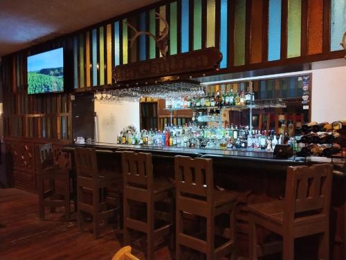 The Halfway Inn في Guerrero Negro: بار به كراسي وجهاز تلفزيون خلفه