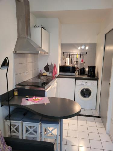 une petite cuisine avec une table et une cuisinière dans l'établissement Studio Tripiers, à Colmar