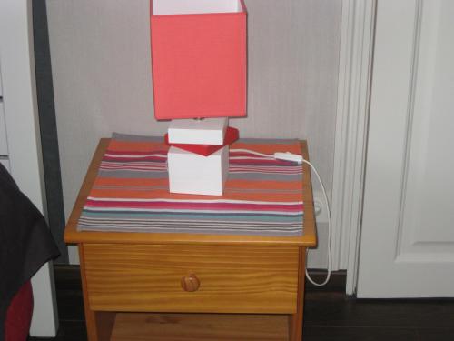 a table with a lamp on top of it at Aux Portes de Rennes Ch. d'hôtes in Chartres-de-Bretagne