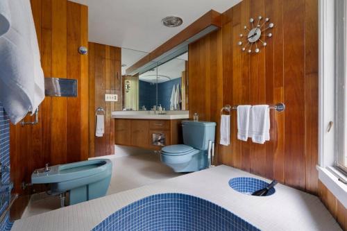 Un baño con un inodoro azul y un lavabo. en Quarry House Mid-Century Modern, en Haddam