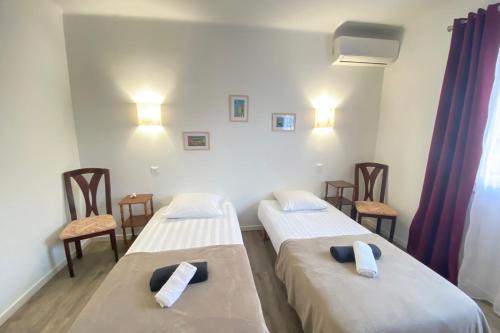 Deux lits dans une salle d'hôpital avec des chaises et des lumières dans l'établissement 06CG Beautiful 2 bedroom apartment - garden, à Cagnes-sur-Mer