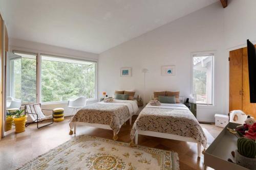 Un dormitorio con dos camas y una gran ventana. en Quarry House Mid-Century Modern, en Haddam