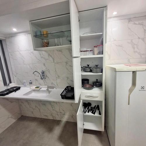 a white bathroom with a sink and a counter at Casa aconchegante no centro de Remanso in Remanso